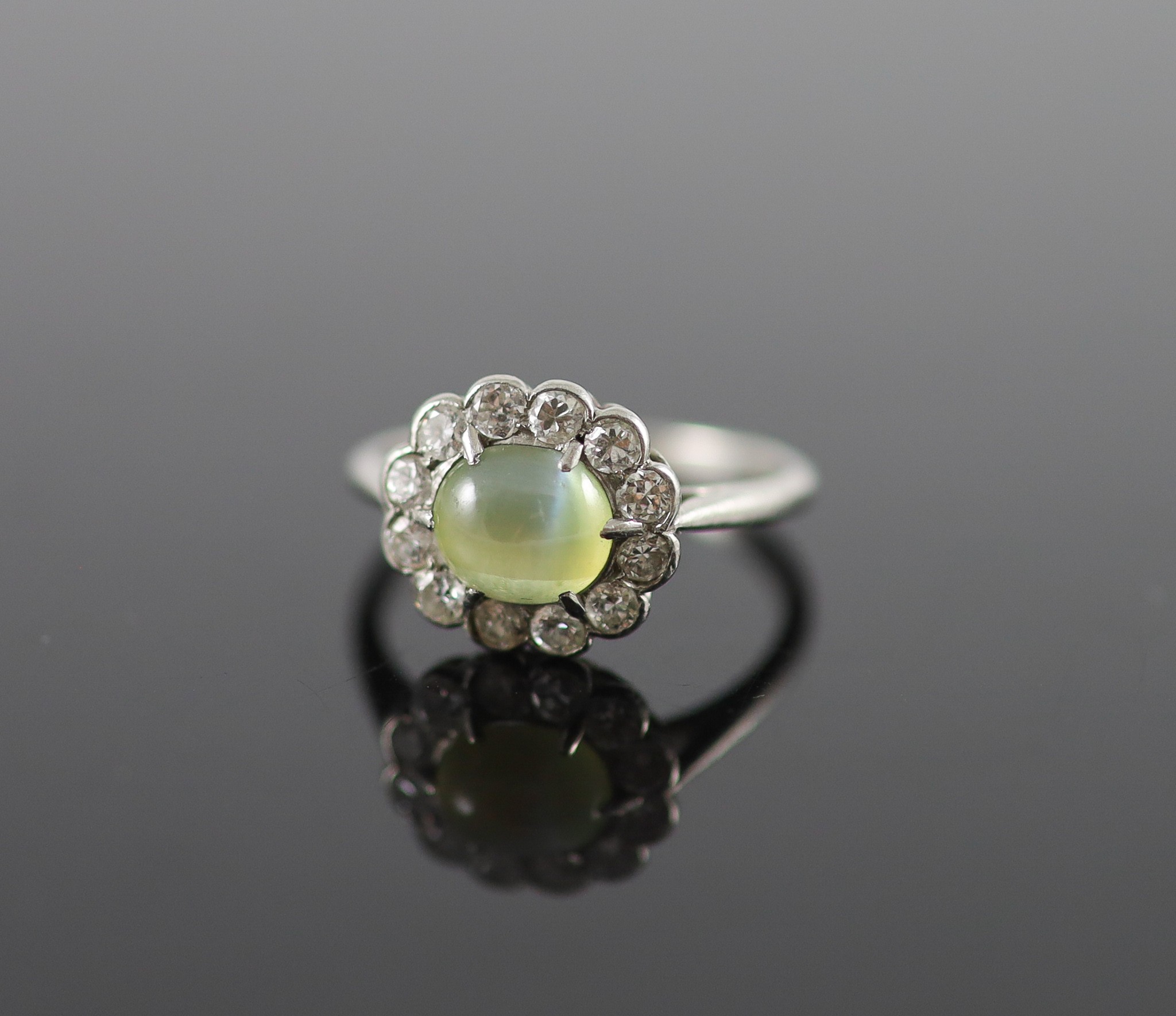 A 1920's/1930's platinum, cats eye chrysoberyl and diamond set oval cluster ring
